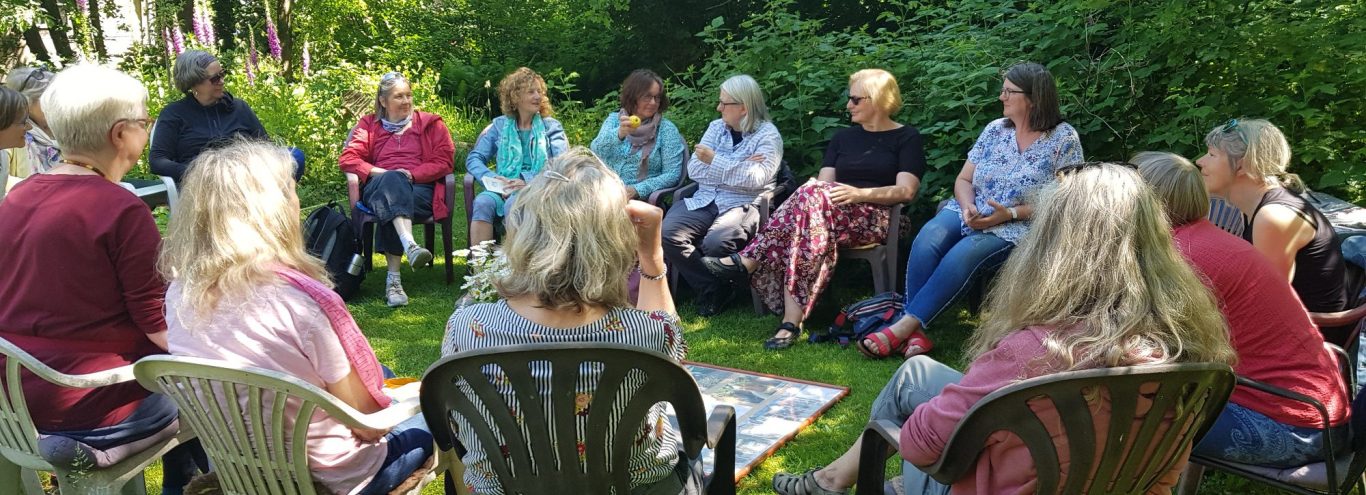 Copyright: Beginen-Oldenburg e.V. Eine Gruppe von Frauen sitzt im Stuhlkreis im Garten.
